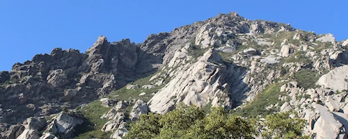 Mountain on a sunny day with fluffy clouds in the blue sky